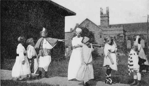 Fig. 23.&mdash;A group of children, showing costumes and a trumpet