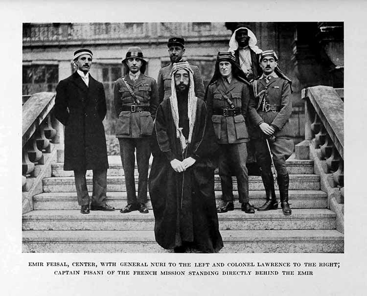Photograph: EMIR FEISAL, CENTER, WITH GENERAL NURI TO THE LEFT
AND COLONEL LAWRENCE TO THE RIGHT, CAPTAIN PISANI OF THE FRENCH
MISSION STANDING DIRECTLY BEHIND THE EMIR